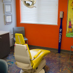 image of pediatric dental room with orange walls and yellow dentist chair